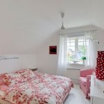 Accogliente camera da letto bianca con decorazioni luminose e disposizione insolita
