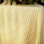 Coperta gialla lavorata a maglia con nappe