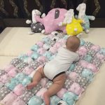 Coperta per bambini a forma di bonbon realizzata con pouf quadrati colorati