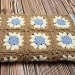 Coperta marrone con fiori bianchi e blu