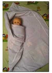 Avvolgi strettamente l'estremità sinistra della coperta attorno al bambino