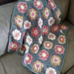 Piccola coperta grigia con elementi floreali