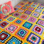 Coperta-copriletto con sfondo giallo e quadrati multicolori
