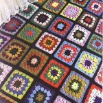 Coperta realizzata con quadrati della nonna lavorati a maglia su sfondo nero