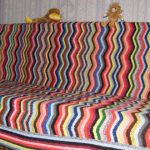 Una coperta per divano realizzata con strisce ondulate multicolori