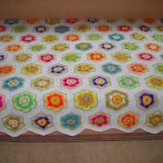 Splendidi elementi floreali su una coperta bianca lavorata a maglia