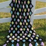 Fiori luminosi per una coperta nera all'uncinetto