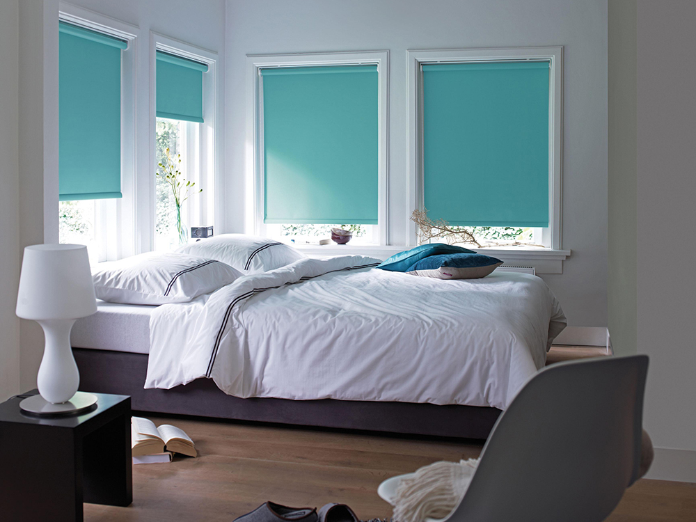 Interno della camera da letto con tende a rullo in tessuto spesso