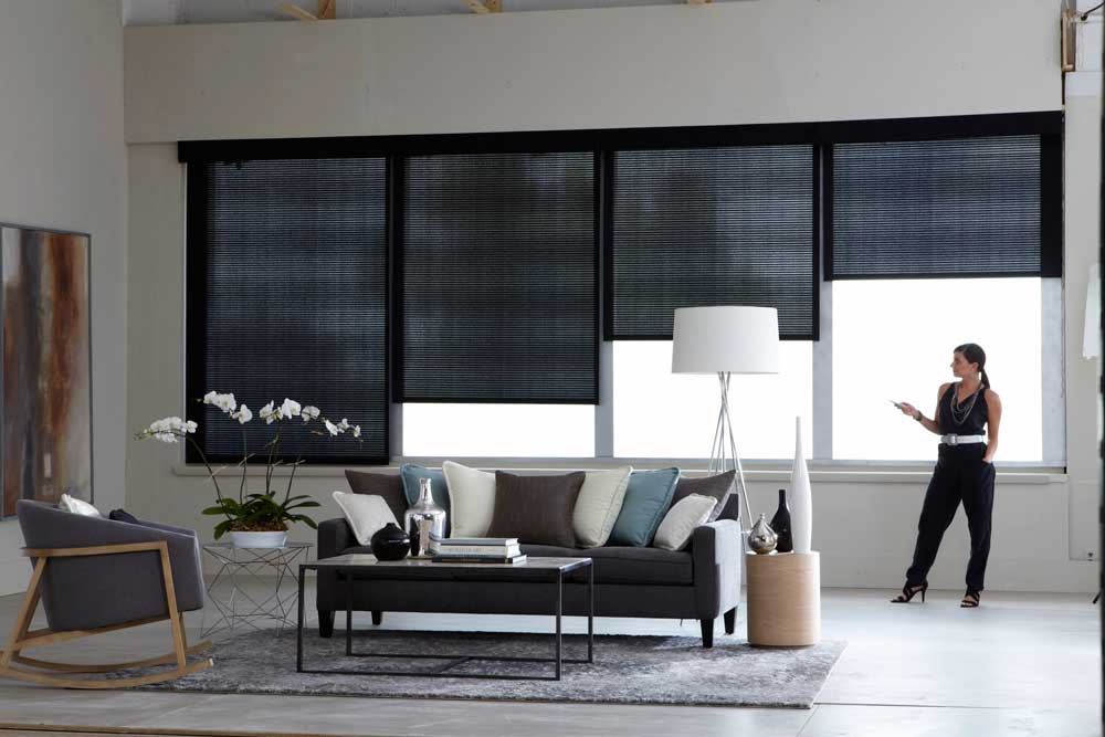 Interno del soggiorno con tende a rullo automatiche Somfy