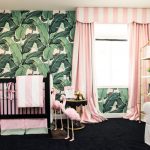 Cameretta con una parete decorativa luminosa e tende a righe rosa
