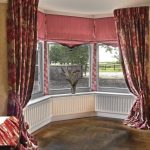 Tende lunghe con fantasia bordeaux per finestra a bovindo della camera da letto