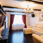 Lunghe tende color bordeaux nell'ingresso con divano beige