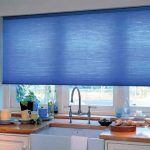 Tenda blu su una finestra di plastica della cucina
