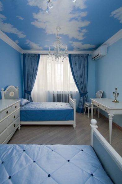 Tende blu con decorazioni blu e mobili bianchi