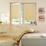 Tende a cassetta beige su una finestra girevole