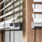 Tende a lamelle a forma di Z su una finestra in legno