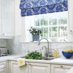 La tenda a rullo bianca e blu sta benissimo sulla finestra della cucina