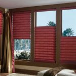 Tende a rullo color borgogna e tende color oro-bordeaux per il soggiorno