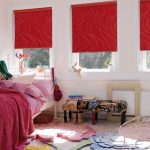 Tende rosse alle finestre della camera da letto per una ragazza