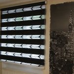 Un poster di una città di notte sul muro di una stanza