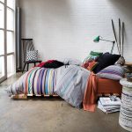 Un materasso alto per dormire sul pavimento è posizionato su una struttura per un utilizzo più confortevole
