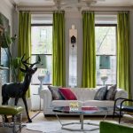Il colore verde nel soggiorno è presente nelle tende, nei mobili e negli accessori