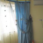 Tulle giallo, tende blu e rete decorativa blu per la cameretta di un giovane marinaio