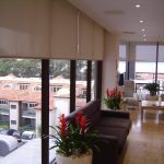 Tende a rullo beige aperte per grandi finestre nel soggiorno
