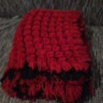 Grande coperta con pompon nei colori rosso e nero