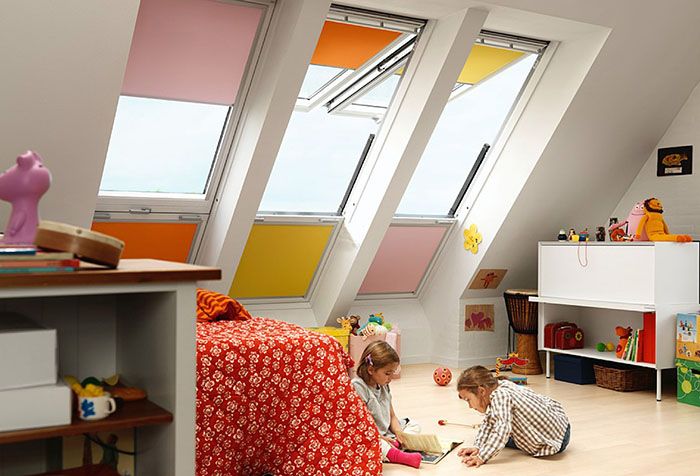 Tende a rullo multicolori alle finestre della cameretta dei bambini in soffitta