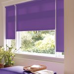 Tende a rullo viola su una finestra di plastica