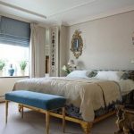 Combinazione di tende romane blu e tende classiche leggere in camera da letto