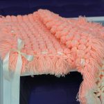 Coperta con pompon color pesca