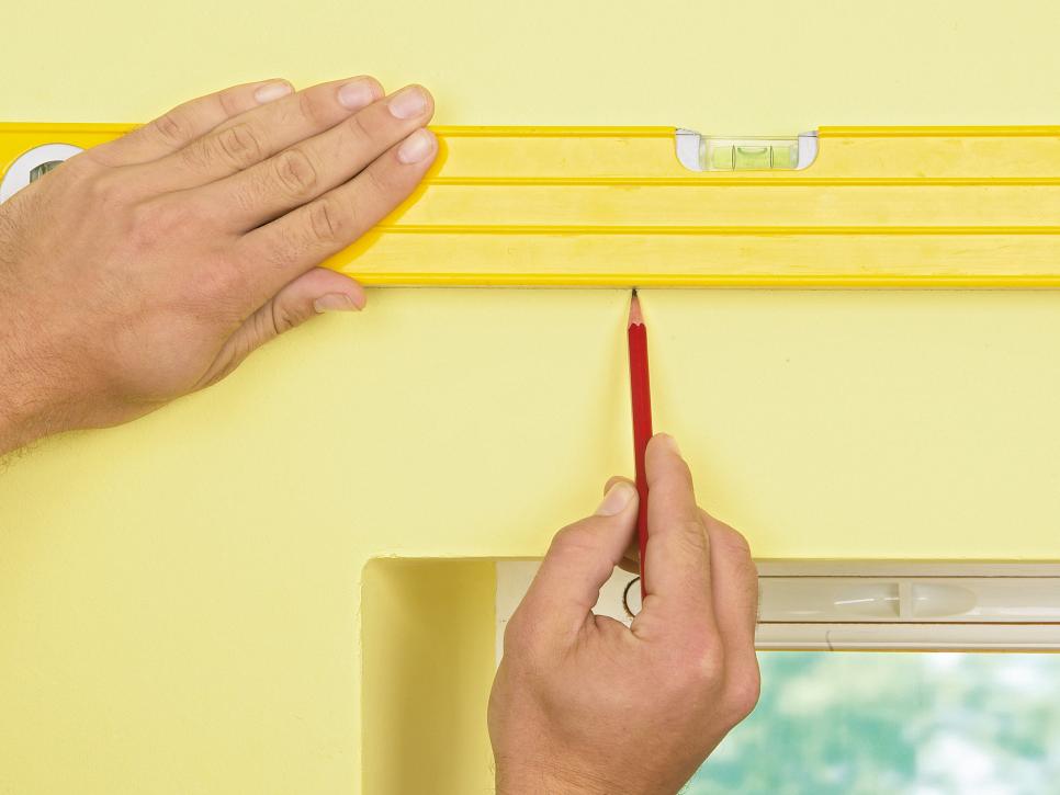 Segnare i punti di fissaggio della cornice utilizzando una livella