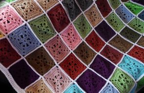 Pătrate multicolore din fire rămase pentru o pătură strălucitoare pe canapea