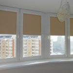 Tende a rullo beige su finestre bianche del balcone