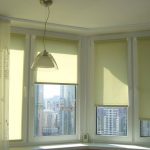 Tulle e tende a rullo sulle finestre del balcone