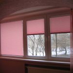 Tende plissettate rosa sul balcone di un appartamento di tre stanze