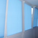 Tende a rullo blu sulle ante di una finestra di plastica