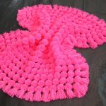 Una coperta con pompon rosa è perfetta per le dimissioni di una bambina dall'ospedale