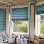 Tende a rullo blu per una finestra a bovindo nella cameretta dei bambini