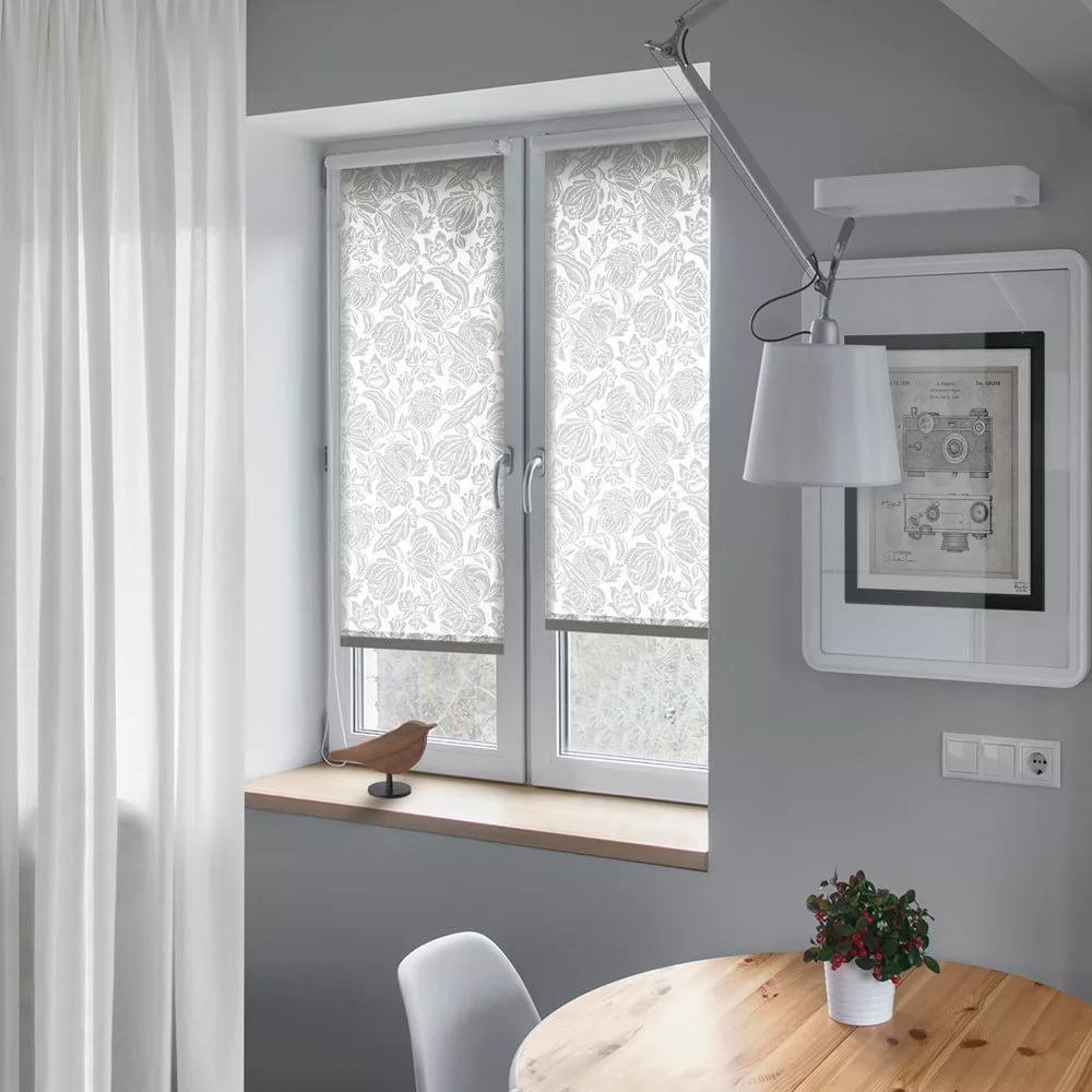 Decorazione delle finestre con una combinazione di tende a rullo e tende dritte