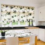 Le tende con fiori verdi stanno bene sulla finestra della cucina