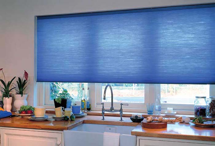 Tenda a rullo blu nell'apertura della finestra della cucina