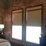 Le tende a rullo opache si adattano bene agli interni della camera da letto in stile loft
