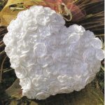 Cuscino a forma di cuore bianco lavorato a maglia con fiori