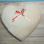 Cuscino a forma di cuore bianco con fiocco