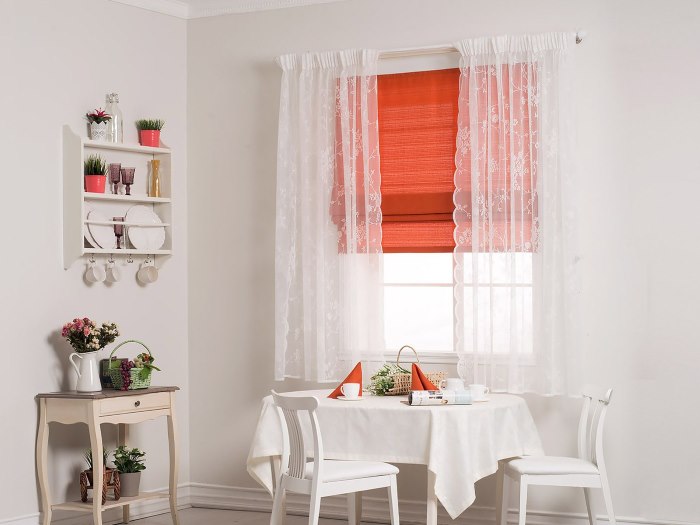 Tulle bianco e tenda romana sulla finestra della cucina