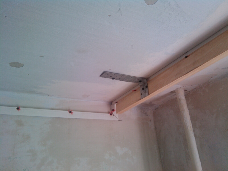 Trave in legno per cornice su soffitto in cemento