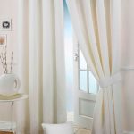 Tende bianche con fermatende sulla porta
